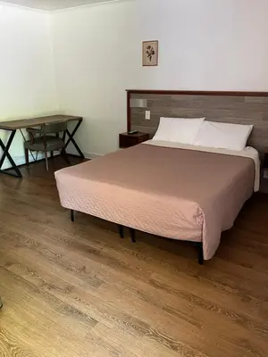 a bedroom with a large bed and a table at Cadet Motel in Cornwall-on-Hudson