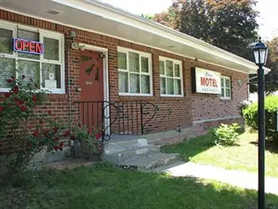 a red brick house with a sign on the door at Cadet Motel in Cornwall-on-Hudson