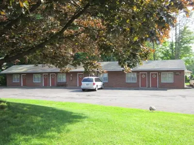 a car parked in a parking lot in front of a building at Cadet Motel in Cornwall-on-Hudson