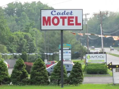 a motel sign in front of a car dealership at Cadet Motel in Cornwall-on-Hudson