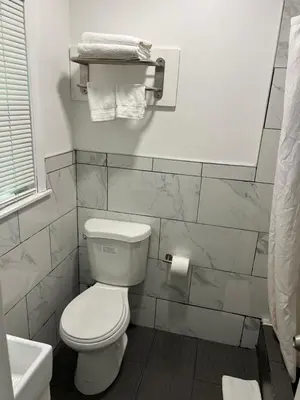 a bathroom with a white toilet and a sink at Cadet Motel in Cornwall-on-Hudson
