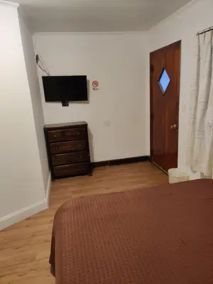 a bedroom with a bed and a tv on a wall at Cadet Motel in Cornwall-on-Hudson