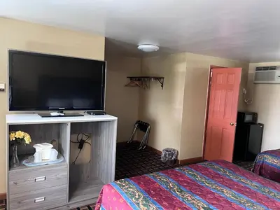 a hotel room with a flat screen tv and a bed at FairBridge Inn Express Milford in Milford