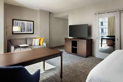 a hotel room with a couch and a television at Hampton Inn & Suites Teaneck/Glenpointe in Teaneck