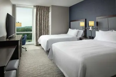 a hotel room with two beds and a television at Hampton Inn & Suites Teaneck/Glenpointe in Teaneck