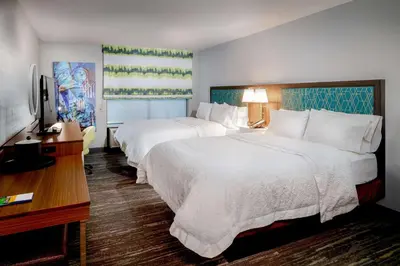 a hotel room with two beds and a television at Hampton Inn By Hilton Paramus in Paramus