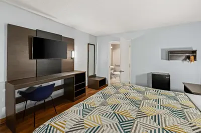 a hotel room with a bed and a flat screen tv at Motel 6 Lester - Philadelphia Airport in Lester