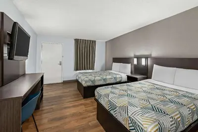 a hotel room with two beds and a flat screen tv at Motel 6 Lester - Philadelphia Airport in Lester
