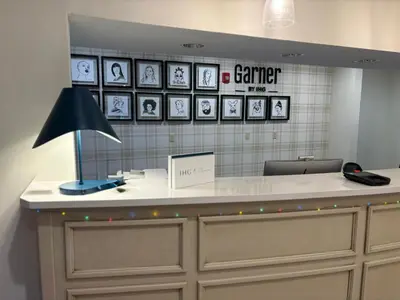 a desk with a lamp and pictures on the wall at Garner Hotel Mahwah by IHG in Mahwah