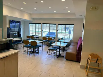 a restaurant with tables and chairs and a couch at Garner Hotel Mahwah by IHG in Mahwah