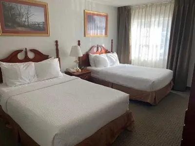 a hotel room with two beds and a window at Host Inn an All Suites Hotel in Wilkes-Barre