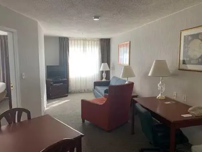 a hotel room with a desk and a living room at Host Inn an All Suites Hotel in Wilkes-Barre