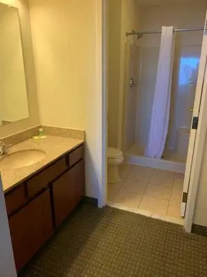 a bathroom with a sink and a toilet and a shower at Host Inn an All Suites Hotel in Wilkes-Barre