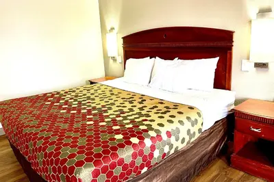 a bed in a hotel room with a colorful bedspread at Red Carpet Inn Philadelphia Airport in Lester
