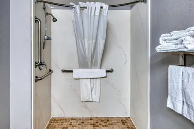 a bathroom with a shower with white towels at Red Carpet Inn Philadelphia Airport in Lester