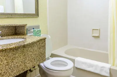a bathroom with a toilet and a sink and a tub at Red Carpet Inn Philadelphia Airport in Lester