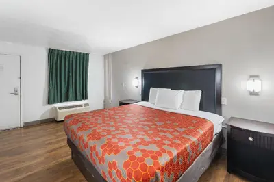 a large bed in a hotel room with a green curtain at Red Carpet Inn Philadelphia Airport in Lester