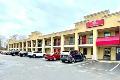 a large building with cars parked in a parking lot at Red Carpet Inn Philadelphia Airport in Lester