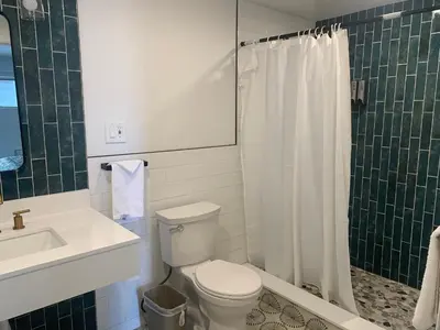 a bathroom with a toilet and a sink and a shower at Domino Inn in North Bergen
