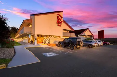 a building with cars parked in a parking lot at Red Roof Inn Binghamton - Johnson City in Binghamton