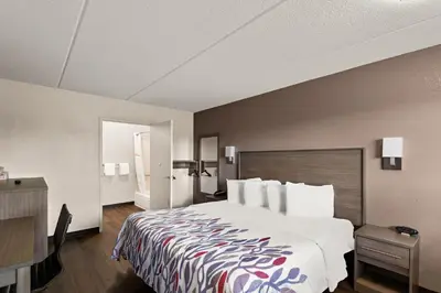 a hotel room with a large bed and a desk at Red Roof Inn Binghamton - Johnson City in Binghamton