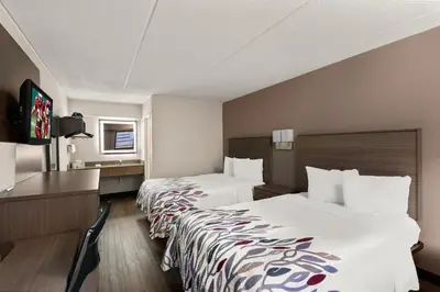 a hotel room with two beds and a desk at Red Roof Inn Binghamton - Johnson City in Binghamton