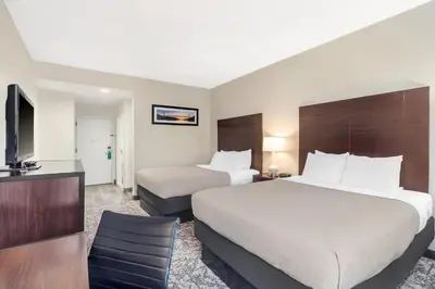 a hotel room with two beds and a flat screen tv at Quality Inn & Suites NJ State Capital Area in Morrisville