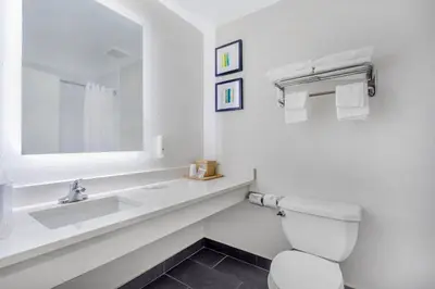 a white bathroom with a sink and a toilet at Quality Inn & Suites NJ State Capital Area in Morrisville