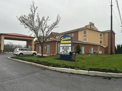 a sign in front of a building with a car at Scottish Inns & Suites - North Hershey in Harrisburg