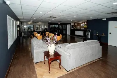 a living room with couches and a table with a vase at Scottish Inns & Suites - North Hershey in Harrisburg