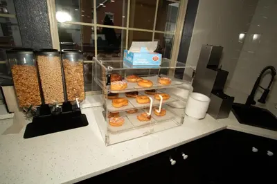 a counter with several trays of donuts on it at Scottish Inns & Suites - North Hershey in Harrisburg