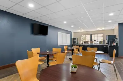 a dining room with tables and chairs and a wall at Scottish Inns & Suites - North Hershey in Harrisburg