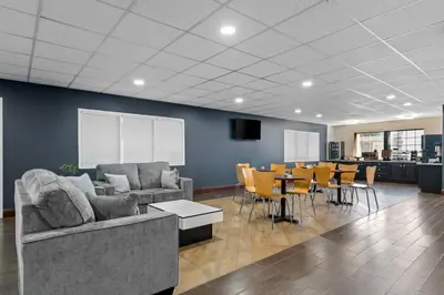 a living room with a couch and a table and chairs at Scottish Inns & Suites - North Hershey in Harrisburg
