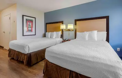 two beds in a hotel room with blue walls at Extended Stay America Suites - Elizabeth - Newark Airport in Elizabeth