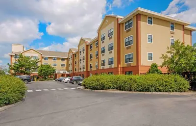 a building with cars parked in a parking lot at Extended Stay America Suites - Elizabeth - Newark Airport in Elizabeth