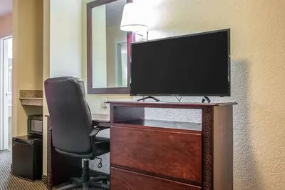 a computer desk with a monitor and a chair at Econo Lodge Harrisburg - Hershey in Harrisburg