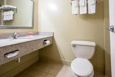 a bathroom with a toilet and a sink at Econo Lodge Harrisburg - Hershey in Harrisburg