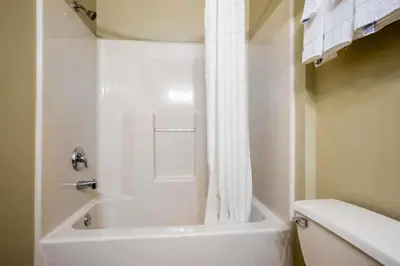 a white bathroom with a tub and a toilet at Econo Lodge Harrisburg - Hershey in Harrisburg