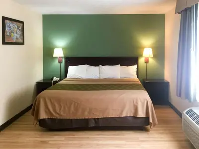 a hotel room with a bed with a green wall at Econo Lodge Harrisburg - Hershey in Harrisburg