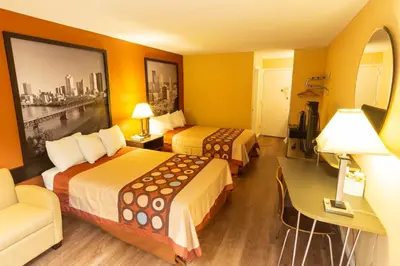 a hotel room with two beds and a desk at Super 8 by Wyndham Carlisle North in Carlisle