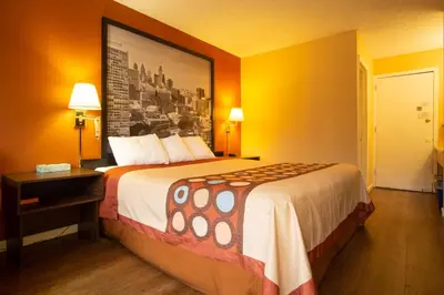 a hotel room with a bed and a picture on the wall at Super 8 by Wyndham Carlisle North in Carlisle