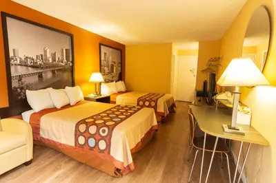 a hotel room with two beds and a desk at Super 8 by Wyndham Carlisle North in Carlisle