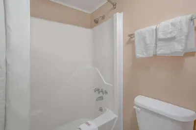 a white bathroom with a shower and a toilet at Super 8 by Wyndham Carlisle North in Carlisle
