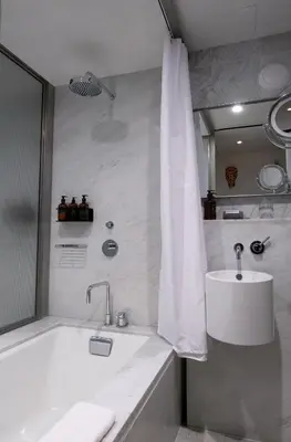 a white bathroom with a tub and a sink at Hotel Alameda, Highline in New York