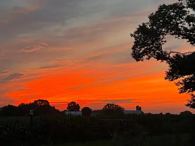 a sunset over a field with a fence at Scottish Inns Ronks in Ronks