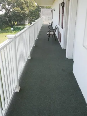 a walkway on a porch with chairs on it at Scottish Inns Ronks in Ronks