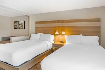 two beds in a hotel room with white sheets at Best Western Plus Heritage Rail Inn & Suites in York