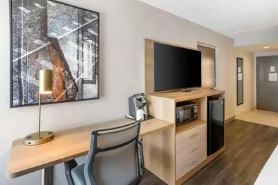 a hotel room with a desk with a tv and a desk at Best Western Plus Heritage Rail Inn & Suites in York