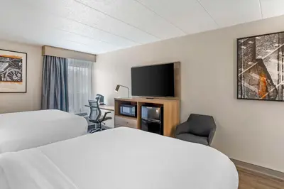 a hotel room with two beds and a flat screen tv at Best Western Plus Heritage Rail Inn & Suites in York