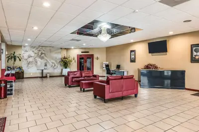 a lobby with red chairs and a waiting room at Red Carpet Inn & Suites in Hazleton